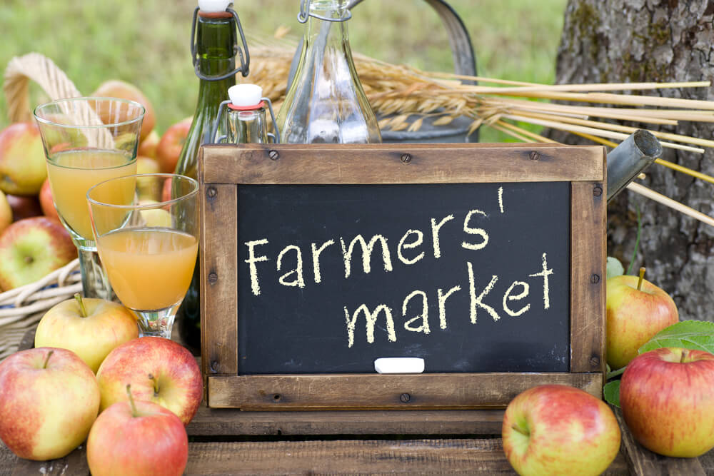 Farmers Market sign and surrounded by apples